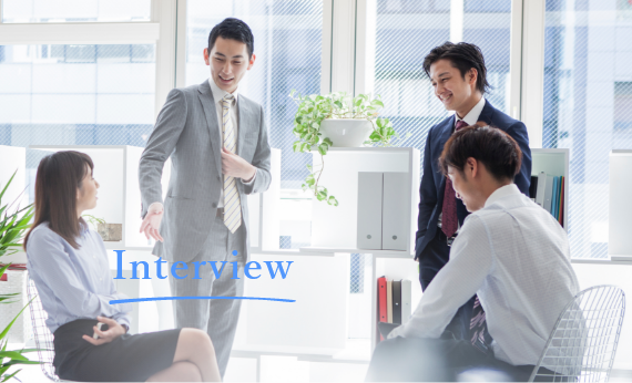 オフィスで会話をするスーツ姿のビジネスパーソンたち、インタビュー形式で事業内容を紹介する様子